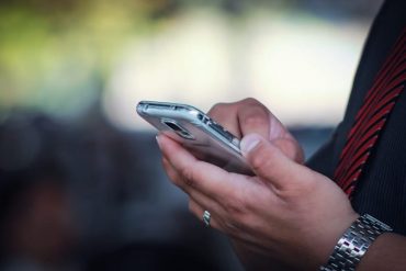 tech worker uses smart phone, with the background blurred