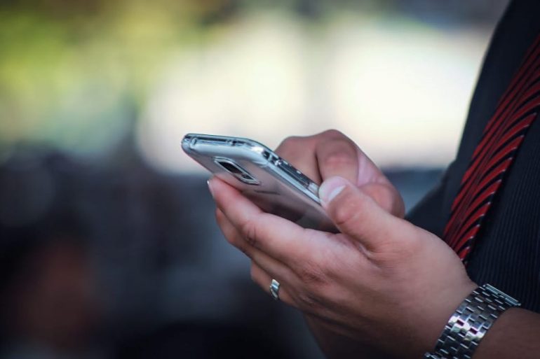 tech worker uses smart phone, with the background blurred