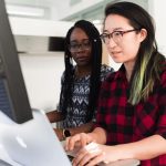 Two women in tech using computers