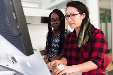 Two women in tech using computers