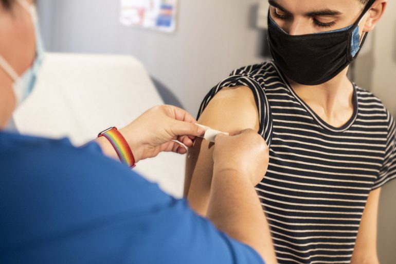 A masked person receiving the COVID-19 vaccination