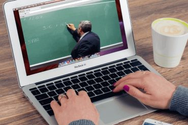Computer screen showing a video of a professor writing something on a chalkboard.