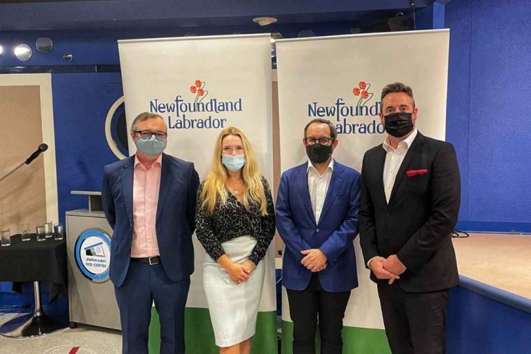 Premier Andrew Furey standing next to Sarah Murphy, Ed Clarke, and Gregory Smyth in front of the Newfoundland and Labrador banner.