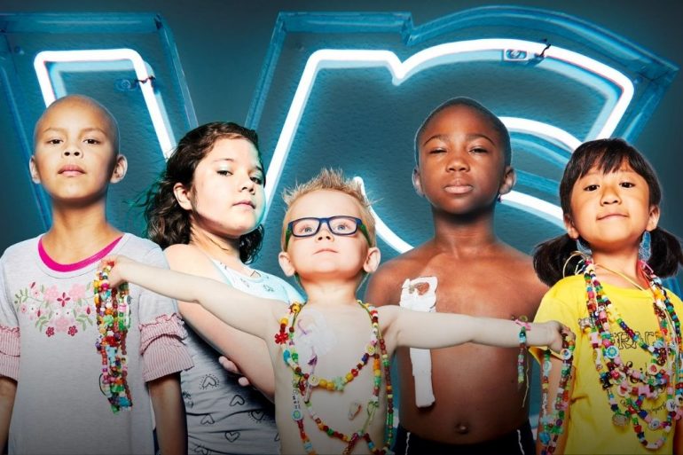 Five kids in superhero poses standing at the foreground, with a neon sign of "V-S" behind them.