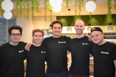 Secoda team in black t-shirts with the Seconda logoposing for a picture