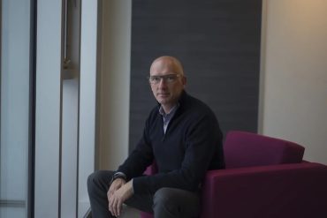 Mike Wessinger, CEO of PointClickCare, sitting on a chair.