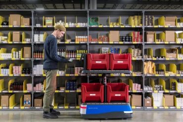 Worker checking package at Shopify fulfillment centre.
