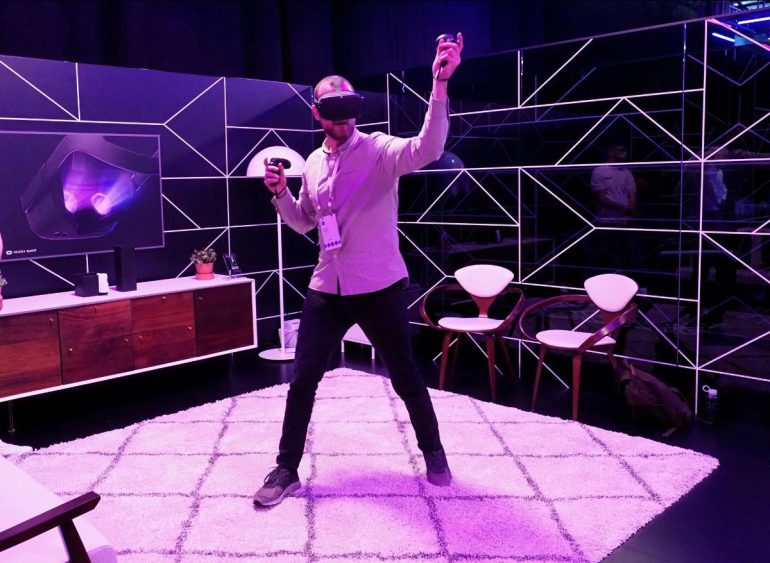 Man using VR headset in a purple room.