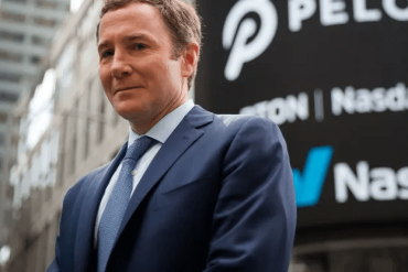 John Foley standing in front of a Peloton sign.