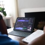 Person investing in stocks and checking data on laptop