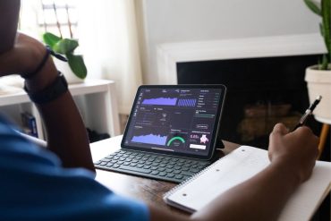 Person investing in stocks and checking data on laptop