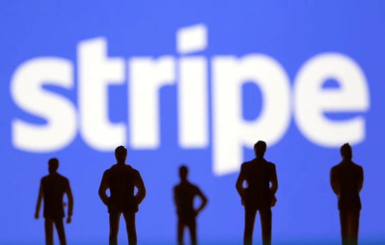 Silouettes of people standing infront of a Stripe logo.