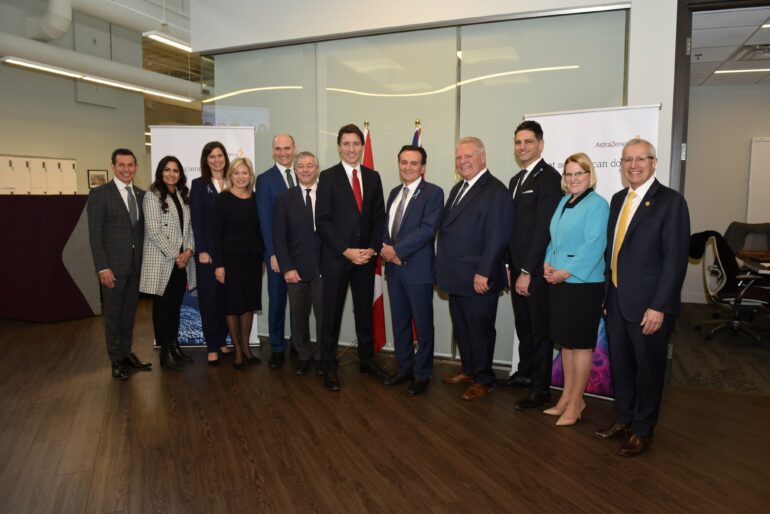 Justin Trudeau and Doug Ford stand within a line of many leaders