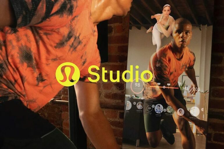 A man works out in front of a mirror with a digital display