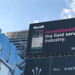 Toronto intersection with billboard for Wingmate that says "revolutionizing the field service industry"