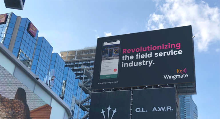 Toronto intersection with billboard for Wingmate that says "revolutionizing the field service industry"