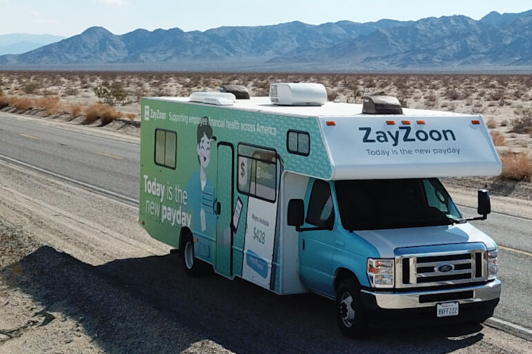 A ZayZoon-branded camper van driving across a US highway.