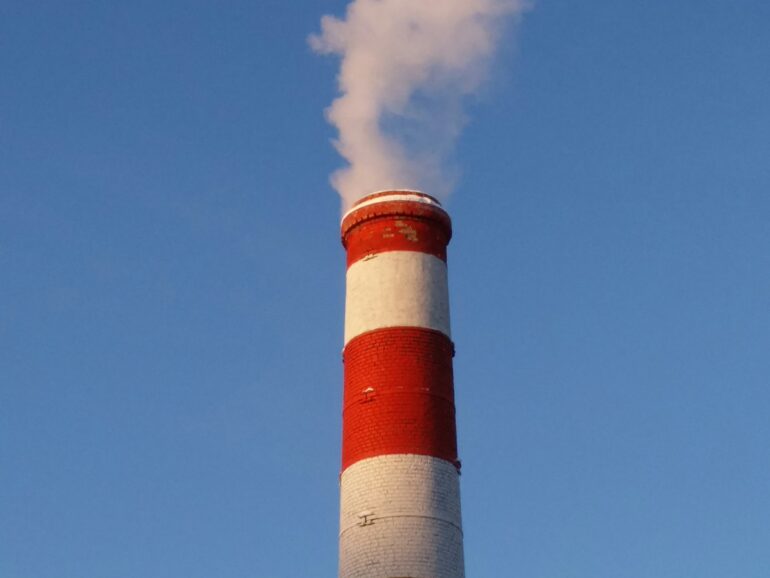 a solitary smoke stack on a blue sky