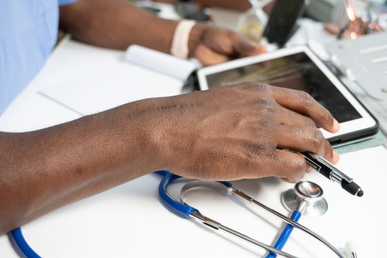 a close-up of a hand on a laptop with stethoscope
