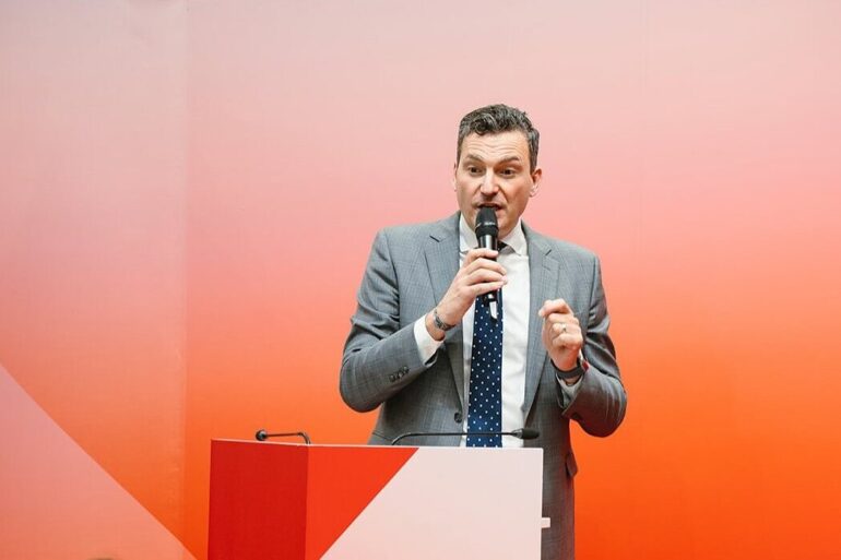 Man speaks into a microphone at a podium