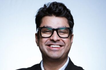 Man with glasses smiles