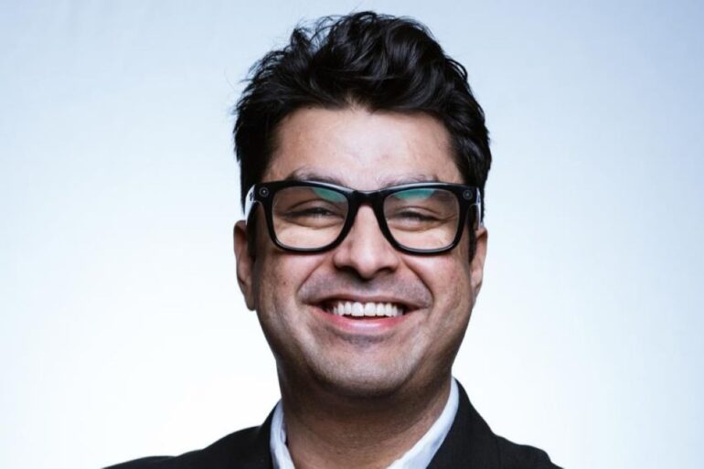 Man with glasses smiles
