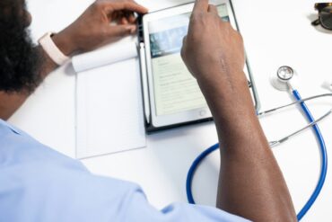 a doctor using a tablet and stethoscope