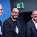Nesto CEO Malik Yacoubi sits on stage with two other unidentified man.