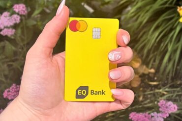 A close-up of a hand holding an EQ Bank card.