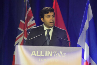 Taleeb Noormohamed behind a podium