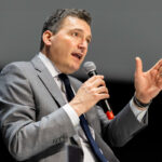 Evan Solomon speaking into a microphone.