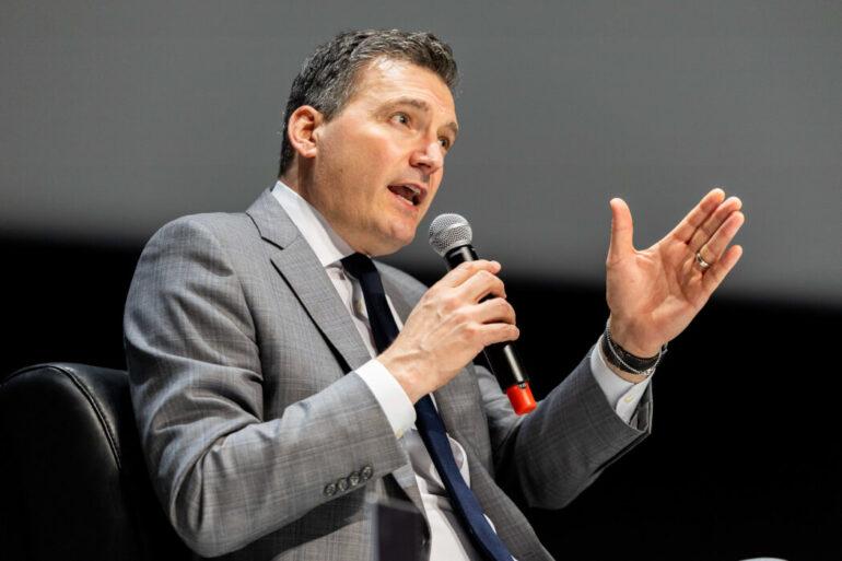 Evan Solomon speaking into a microphone.