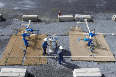 An aerial shot of two men working beside a Kathairos Solutions Nitrogen Tank